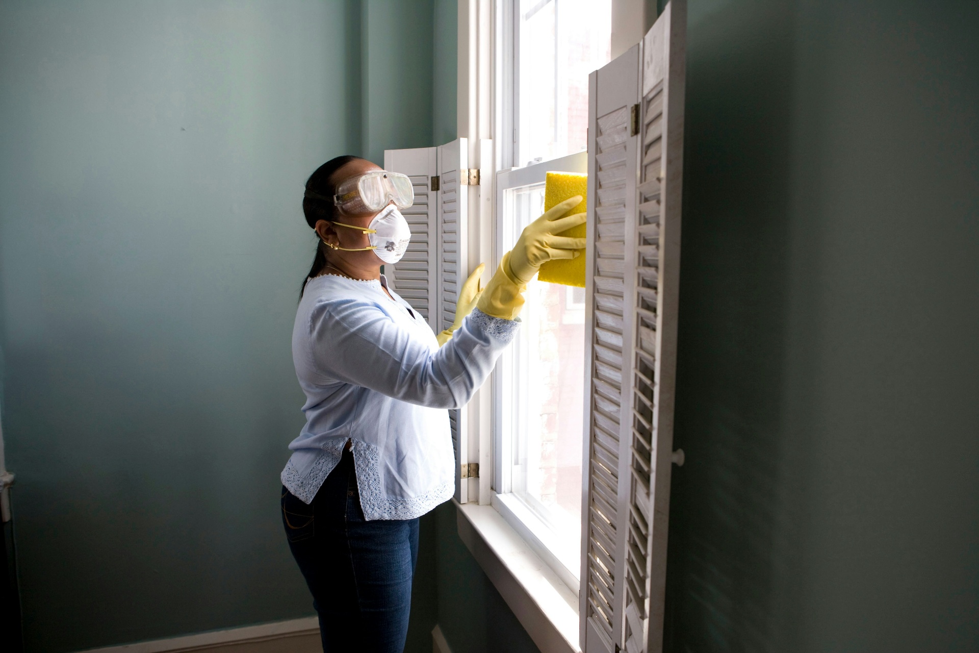 Cleaning interior window glass with a squeegee to a streak-free shine in a Fountain Michigan home